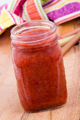 homemade rhubarb and strawberry jam in glass jar on table