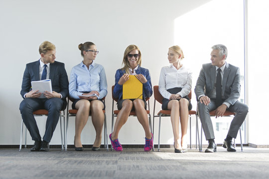 People sitting in a row, waiting for job interview