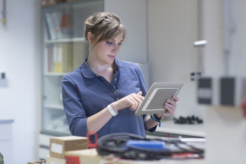 Technician in workshop using digital tablet