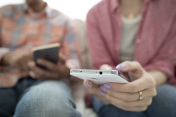The couple are looking at each of the smartphone