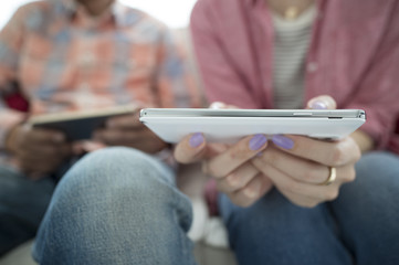 Men and women are looking at smart phone on the sofa