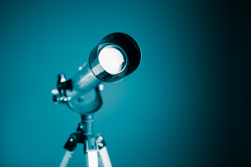 telescope on blue background with copy-space