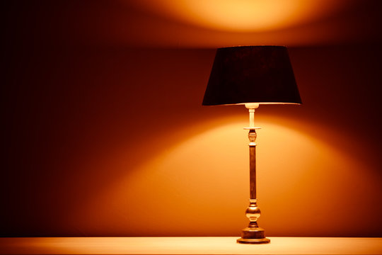 interior lamp with warm light against plaster wall background