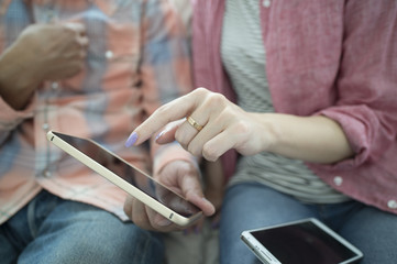 Obraz premium The couple are looking at a smart phone on the sofa