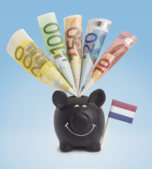 Various european banknotes in a happy piggybank of Netherlands.(