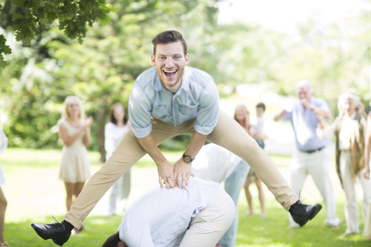 Happy young man playing leapfrog in park