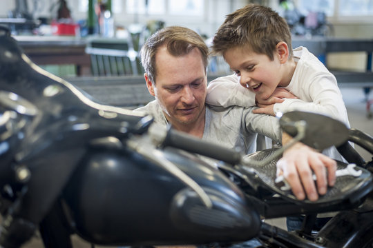 Father and son maintaining vintage moped