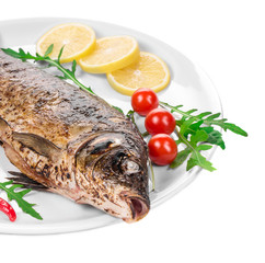 Grilled carp with vegetables on plate.