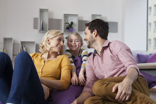 Happy mother, father and daughter at home