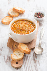 tomato soup with rice and vegetables in a saucepan and bread