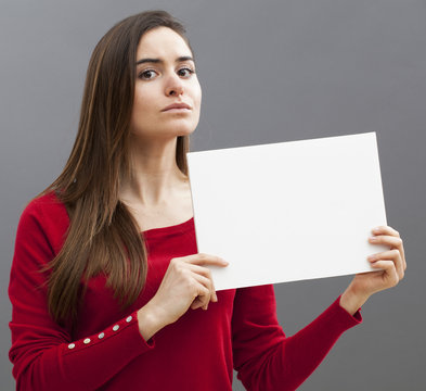proud young woman wearing a red sweater holding a blank board for focusing on claim