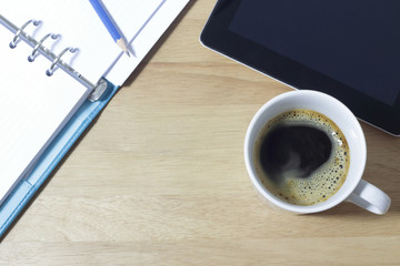Office table with notepad  and coffee cup. View from above with copy space