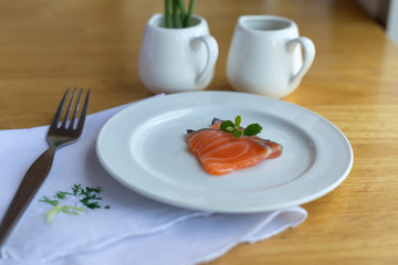salmon in white dish and fork on table
