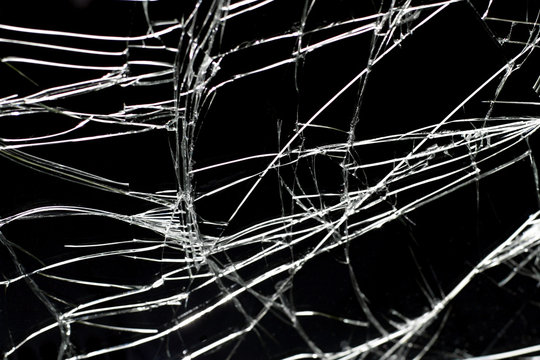 Broken windshield closeup against black background