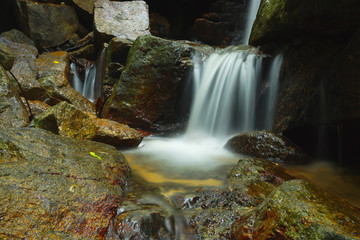 Fototapeta na wymiar Beautiful of small waterfall flowing over the rock in the fores