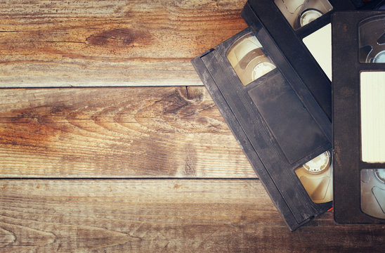 stack of VHS video tape cassette over wooden background
