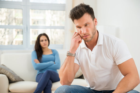 Defocused Woman In Front Of Sad Young Man