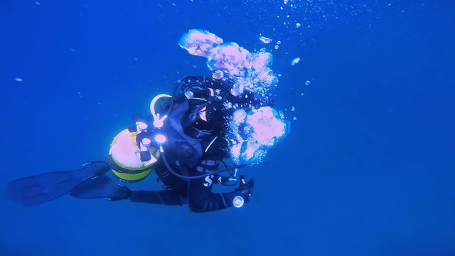 Scuba Diver Descending into Blue Water
