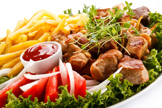 Kebab - grilled meat with French fries and vegetables 