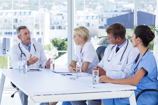 Team Of Doctor Discussing Together During Meeting 