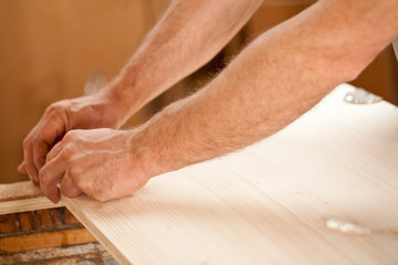 man's hand working on wood