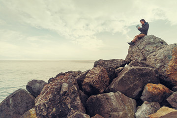 Traveler girl working on digital tablet on coast