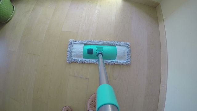 woman mopping floor at home. Camera hang on mop handle. 4K