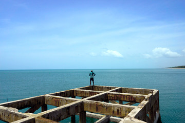 Fishermen are fishing on old harbor at the sea.