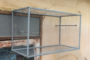 Empty bird cage on the wall