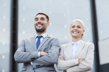 smiling businessmen standing over office building