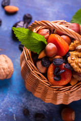 Healthy concept: assortment of dry fruits and nuts on blue rustic background. Selective focus