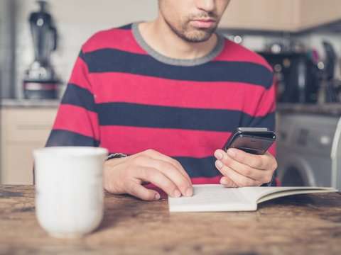Young man using smart phone and reading