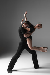 two young modern ballet dancers on gray studio background 