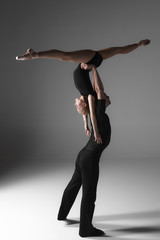two young modern ballet dancers on gray studio background 