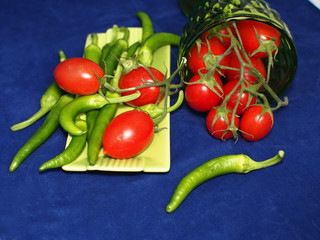 Red tomatoes and chili peppers on blue background