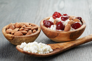 cottage cheese with preserved strawberry in wood bowl on oak
