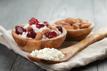 cottage cheese with preserved strawberry in wood bowl on oak