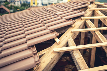Construction site of new house, roof building with brown tiles and timber. Contractor building roof of new house - obrazy, fototapety, plakaty
