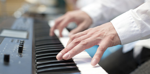 player pianist fingers on keyboard close up