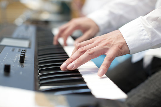 player pianist fingers on keyboard close up