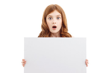 Naklejka premium Surprised girl holding white board 