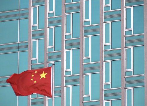 Chinese flag with modern office building. The picture was taken in New York in 2014.