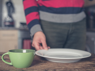 Man setting table in kitchen
