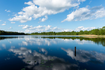 Obraz na płótnie Canvas White clouds on the blue sky over blue lake
