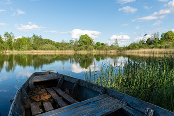 Obraz premium White clouds on the blue sky over blue lake with boats and board