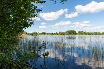 White clouds on the blue sky over blue lake
