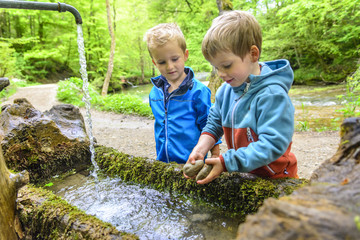 zwei Jungs spielen am Brunnen