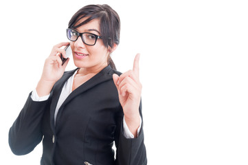 Saleswoman talking on the phone and making wait gesture