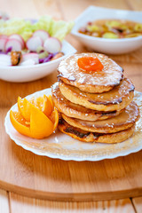 Fototapeta na wymiar Pancakes and orange in white plate on wooden table.