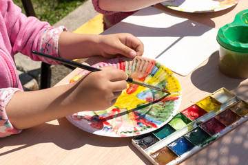 Obraz na płótnie Canvas Young Girl Painting a Paper Plate